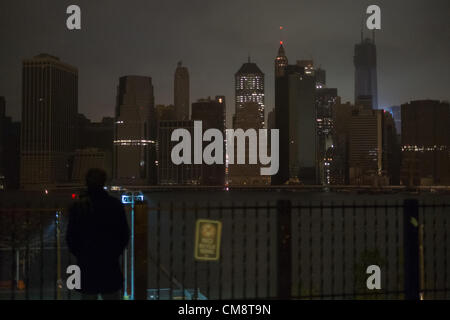 29. Oktober 2012, Brooklyn, NY, USA.  Menschen auf der Brooklyn Heights Promenade betrachten einen abgedunkelten Skyline von Manhattan, nachdem Hurrikan Sandy Strom, Teile von Manhattan geschnitten. Stockfoto