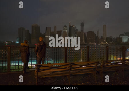 29. Oktober 2012, Brooklyn, NY, USA.  Menschen auf der Brooklyn Heights Promenade betrachten einen abgedunkelten Skyline von Manhattan, nachdem Hurrikan Sandy Strom, Teile von Manhattan geschnitten. Stockfoto