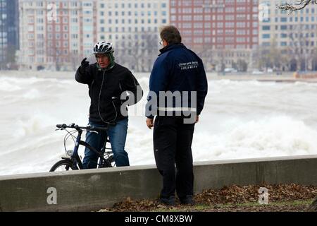 Chicago, Illinois. 30. Oktober 2012. Ein Sicherheitsbeamter von Chicago Park District hält einen Mann von Radfahren auf den Radweg am Seeufer in der Nähe von North Avenue Beach. Große Wellen, die durch Hurrikan Sandy Reste, einige von mehr als 20 Fuß erzeugt gefährlichen Bedingungen geschaffen. Stockfoto
