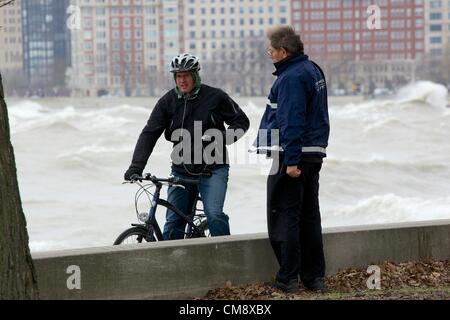 Chicago, Illinois. 30. Oktober 2012. Ein Sicherheitsbeamter von Chicago Park District hält einen Mann von Radfahren auf den Radweg am Seeufer in der Nähe von North Avenue Beach. Große Wellen, die durch Hurrikan Sandy Reste, einige von mehr als 20 Fuß erzeugt gefährlichen Bedingungen geschaffen. Stockfoto