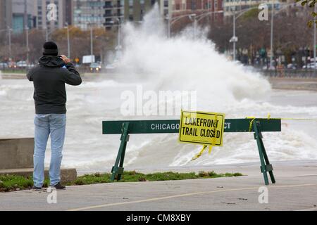 Chicago, Illinois. 30. Oktober 2012. Ein Mann nimmt ein Foto von einer großen Welle stürzt in der Ufermauer in der Nähe von North Avenue Beach. Wellen von den Überresten des Hurrikans Sandy, etwas höher als 20 Fuß, führte zur Schließung von der Seepromenade Rad- und Wanderweg. Stockfoto