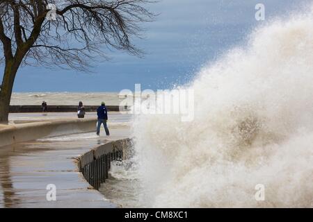 Chicago, Illinois. 30. Oktober 2012. Eine große Welle stürzt in der Ufermauer am Nordstrand Allee als ein Mann-Risiken zu Fuß entlang der Ufermauer. 60 km/h Windböen von Hurrikan Sandy Reste erzeugt Wellen, einige von mehr als 20 Fuß. Stockfoto