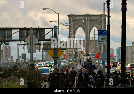 31. Oktober 2012, New York, NY, USA.  Zwei Tage nach dem Hurrikan Sandy Teile von New York City verwüstet, überqueren Pendler die Brooklyn Bridge in lower Manhattan in Autos, zu Fuß oder auf dem Fahrrad. Stockfoto