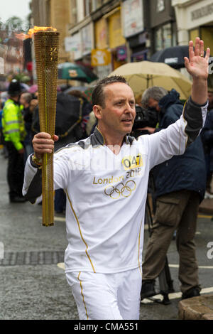 Northampton UK. 2. Juli 2012. Andy Wightman trägt die Olympische Fackel nach unten St Giles Street vor dem Guildhall Northampton Town Center, genauso wie der Regen beginnt. Stockfoto