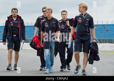 05.07.2012. Silverstone Circuit, Northampton, England, UK. Deutsche Formel1-Fahrer Sebastian Vettel (M) von Red Bull, seinem Renningenieur Guillaume Rocquelin (L), seine Leistung Ingenieur Tim Maylon (2. R) und seine Fitness-Coach Heikki Huovinen (R) gehen nahe die Rennstrecke von Silverstone in Northamptonshire. Die Formula One Grand Prix von Großbritannien statt findet am 8. Juli 2011. Stockfoto