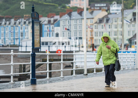 Aberystwyth, Wales, UK. Freitag, 6. Juli 2012 schützen Menschen in Aberystwyth vor dem Schlagregen. Die Environment Agency hat Amber Alerts Warnung vor der Gefahr von Überschwemmungen auf Flüssen in Wales, und einen Monat im Wert von Regen wird vorausgesagt, um in Teilen des Vereinigten Königreichs an nur einem Tag fallen.  Foto © Keith Morris Stockfoto