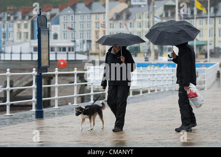 Aberystwyth, Wales, UK. Freitag, 6. Juli 2012 schützen Menschen in Aberystwyth vor dem Schlagregen. Die Environment Agency hat Amber Alerts Warnung vor der Gefahr von Überschwemmungen auf Flüssen in Wales, und einen Monat im Wert von Regen wird vorausgesagt, um in Teilen des Vereinigten Königreichs an nur einem Tag fallen.  Foto © Keith Morris Stockfoto