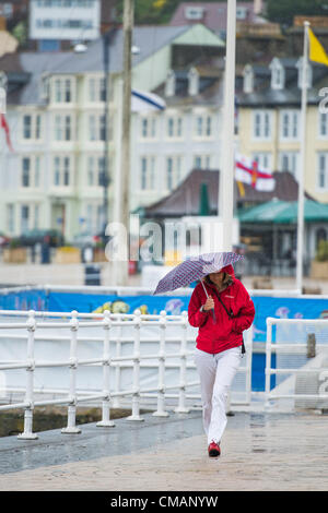 Aberystwyth, Wales, UK. Freitag, 6. Juli 2012 schützen Menschen in Aberystwyth vor dem Schlagregen. Die Environment Agency hat Amber Alerts Warnung vor der Gefahr von Überschwemmungen auf Flüssen in Wales, und einen Monat im Wert von Regen wird vorausgesagt, um in Teilen des Vereinigten Königreichs an nur einem Tag fallen.  Foto © Keith Morris Stockfoto