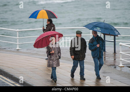 Aberystwyth, Wales, UK. Freitag, 6. Juli 2012 schützen Menschen in Aberystwyth vor dem Schlagregen. Die Environment Agency hat Amber Alerts Warnung vor der Gefahr von Überschwemmungen auf Flüssen in Wales, und einen Monat im Wert von Regen wird vorausgesagt, um in Teilen des Vereinigten Königreichs an nur einem Tag fallen.  Foto © Keith Morris Stockfoto