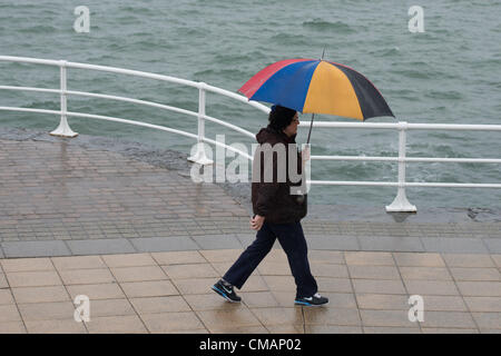 Aberystwyth, Wales, UK. Freitag, 6. Juli 2012 schützen Menschen in Aberystwyth vor dem Schlagregen. Die Environment Agency hat Amber Alerts Warnung vor der Gefahr von Überschwemmungen auf Flüssen in Wales, und einen Monat im Wert von Regen wird vorausgesagt, um in Teilen des Vereinigten Königreichs an nur einem Tag fallen.  Foto © Keith Morris Stockfoto