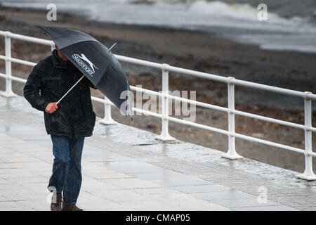 Aberystwyth, Wales, UK. Freitag, 6. Juli 2012 schützen Menschen in Aberystwyth vor dem Schlagregen. Die Environment Agency hat Amber Alerts Warnung vor der Gefahr von Überschwemmungen auf Flüssen in Wales, und einen Monat im Wert von Regen wird vorausgesagt, um in Teilen des Vereinigten Königreichs an nur einem Tag fallen.  Foto © Keith Morris Stockfoto