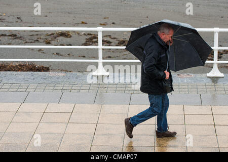 Aberystwyth, Wales, UK. Freitag, 6. Juli 2012 schützen Menschen in Aberystwyth vor dem Schlagregen. Die Environment Agency hat Amber Alerts Warnung vor der Gefahr von Überschwemmungen auf Flüssen in Wales, und einen Monat im Wert von Regen wird vorausgesagt, um in Teilen des Vereinigten Königreichs an nur einem Tag fallen.  Foto © Keith Morris Stockfoto