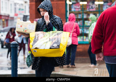 Aberystwyth, Wales, UK. Freitag, 6. Juli 2012 schützen Menschen in Aberystwyth vor dem Schlagregen. Die Environment Agency hat Amber Alerts Warnung vor der Gefahr von Überschwemmungen auf Flüssen in Wales, und einen Monat im Wert von Regen wird vorausgesagt, um in Teilen des Vereinigten Königreichs an nur einem Tag fallen.  Foto © Keith Morris Stockfoto