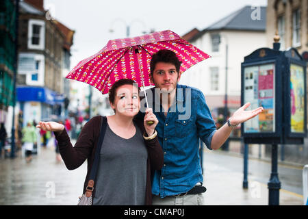 Aberystwyth, Wales, UK. Freitag, 6. Juli 2012 junges Paar in Aberystwyth Zuflucht vor den Schlagregen. Die Environment Agency hat Amber Alerts Warnung vor der Gefahr von Überschwemmungen auf Flüssen in Wales, und einen Monat im Wert von Regen wird vorausgesagt, um in Teilen des Vereinigten Königreichs an nur einem Tag fallen.  Foto © Keith Morris Stockfoto