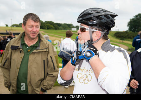 6. Juli 2012, Hadleigh Farm, Essex. Die Olympische Fackel durchläuft der Olympischen Mountainbike Ort wo Dan Jarvis die Fackel um einen Abschnitt des Rennens nimmt vor Übergabe an Läufer Kim Axford route und ab in Richtung Basildon und Grautöne. Das Wetter wurde zu trocken und sonnig, wie die Fackel an der Abendkasse gegen den neuesten Wettertrend nass, nass, nass ankam. Stockfoto