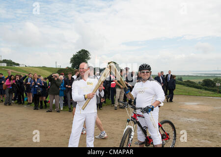 6. Juli 2012, Hadleigh Farm, Essex, England. Die Olympische Fackel durchläuft der Olympischen Mountainbike Ort wo Dan Jarvis (L) die Fackel um einen Abschnitt des Rennens nimmt route vor der Übergabe an Läufer Kim Axford (nicht abgebildet) und ab in Richtung Basildon und Grautöne. Das Wetter wurde zu trocken und sonnig, wie die Fackel am Veranstaltungsort angekommen. Stockfoto