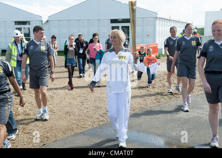 6. Juli 2012, Hadleigh, Essex, England. Die Olympische Fackel durchläuft der Mountain Biking Veranstaltungsort auf der Hadleigh Farm. Läufer Kim Axford nimmt die Fackel aus dem Ort in Richtung Basildon. Kim wurde von ihrem Sohn nominiert, nach Jahren des Unterrichtens Passform und Menschen helfen Aufenthalt gesund halten. Stockfoto