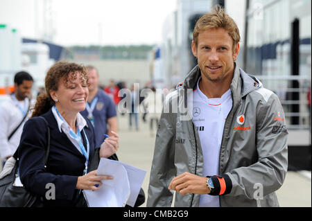 08.07.2012 Towcester, England. Jenson Button von Großbritannien und Vodafone McLaren Mercedes Zeichen ein Autogramm für Zuschauer, wie er im Fahrerlager am Renntag Morgen beim britischen Grand Prix Santander, Runde 9 der 2012 FIA Formel 1 Weltmeisterschaft in Silverstone ankommt. Stockfoto