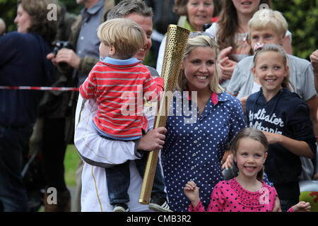 Hemel Hempstead, Großbritannien. 8. Juli 2012. Fackel-Träger 106 posiert für Fotos mit seiner Familie am Tag 50 des Olympischen Fackellaufs in Hemel Hempstead Stockfoto