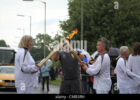 Hemel Hempstead, Großbritannien. 8. Juli 2012. Die Flamme wird von einer Fackel zur anderen am 50. Tag des Olympischen Fackellaufs in Hemel Hempstead übertragen Stockfoto