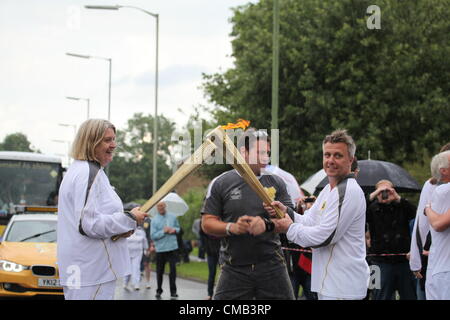 Hemel Hempstead, Großbritannien. 8. Juli 2012. Die Flamme wird von einer Fackel zur anderen am 50. Tag des Olympischen Fackellaufs in Hemel Hempstead übertragen Stockfoto