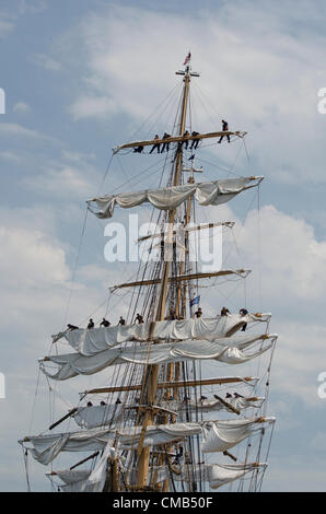 DIE US-Küstenwache rollt die Segel auf Amerikas großem Schiff Eagle, während es an seinem Heimathafen Fort Trumbull, New London, Connecticut, anlegt, wo es im Sommer oft zu sehen ist. Der Eagle ist das einzige Segelschiff im aktiven Dienst des amerikanischen Militärs. Original Live News Bildunterschrift: New London, Connecticut, USA - 7. Juli 2012: Das Hochschiff Eagle der US-Küstenwache landet während des OpSail 2012 Festivals in Fort Trumbull. Kadetten hoch oben in der Takelage rollten die Segel nach der Parade von Sail während der Feierlichkeiten zum 200. Jahrestag des Krieges von 1812. Stockfoto