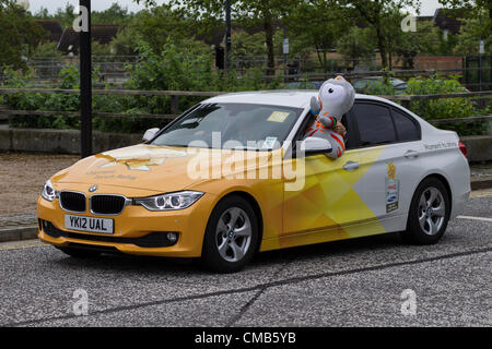 Milton Keynes. Buckinghamshire.UK.9th Juli 2012 Tag 52 des Olympischen Fackellaufs. Die Massen warten auf die ersten Fackelträger, die Gail Emms, offizielle olympische Auto war. Stockfoto