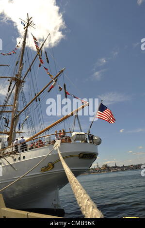 New London, Connecticut, USA - 9. Juli 2012: Der Stern von der US-Küstenwache Schulschiff Adler mit der amerikanischen Flagge, gesehen hier in Fort Trumbull, am letzten Tag der Sail 2012 CT, feiert die Zweihundertjahrfeier der Krieg von 1812 und der penning Star Spangled Banner, die Nationalhymne festgemacht. Im Hintergrund ist die Skyline der City of New London zu sehen. Kopieren Sie Raum. Stockfoto