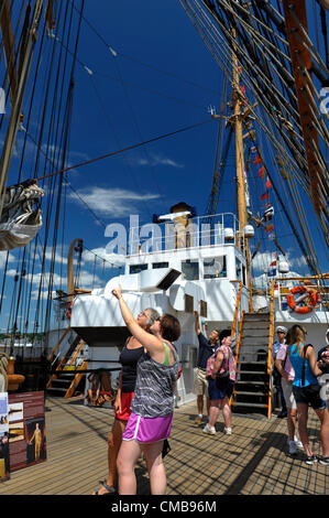 New London, Connecticut, USA - 9. Juli 2012: Susan Roberts, formal von Chippenham, Wiltshire, England und jetzt von West Hartford Connecticut und ihrer Tochter Laura Doten erkunden Sie die US-Küstenwache Schiff Adler im Hafen von Fort Trumbull während Sail 2012 CT, feiert die Zweihundertjahrfeier der Krieg von 1812 und der penning Star Spangled Banner, die Nationalhymne. Stockfoto