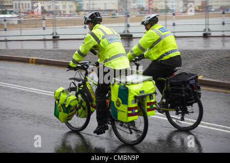 Weymouth, Großbritannien Donnerstag, 12. Juli 2012.  Krankenwagen und Polizei Männer fahren Sie vorbei am Push-bikes Stockfoto