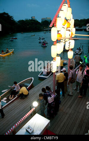 13. Juli 2012, Tokio, Japan – geduldig Chidorigafuchi Parkbesucher im Boot den Beginn der Toro Nagashi-Zeremonie in Tokio. Toro Nagashi ist eine japanische Zeremonie, wo Teilnehmer Put Papierlaternen im Wasser schweben; "Toro" ist ein japanisches Wort, das es bedeutet 'Laterne' und "Nagashi" bedeutet "Kreuzfahrt, fließen". Nach der Überlieferung zeigen diese Leuchten eine Möglichkeit für die Geister der Toten ins Jenseits. Stockfoto