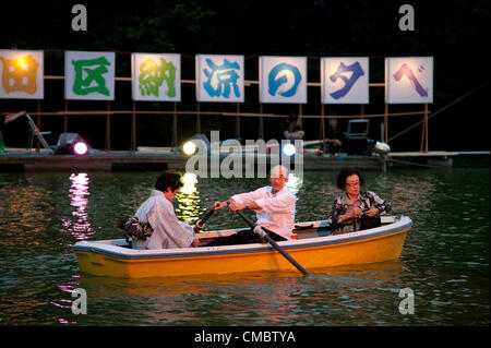 13. Juli 2012, Tokio, Japan – geduldig Chidorigafuchi Parkbesucher im Boot den Beginn der Toro Nagashi-Zeremonie in Tokio. Toro Nagashi ist eine japanische Zeremonie, wo Teilnehmer Put Papierlaternen im Wasser schweben; "Toro" ist ein japanisches Wort, das es bedeutet 'Laterne' und "Nagashi" bedeutet "Kreuzfahrt, fließen". Nach der Überlieferung zeigen diese Leuchten eine Möglichkeit für die Geister der Toten ins Jenseits. Stockfoto