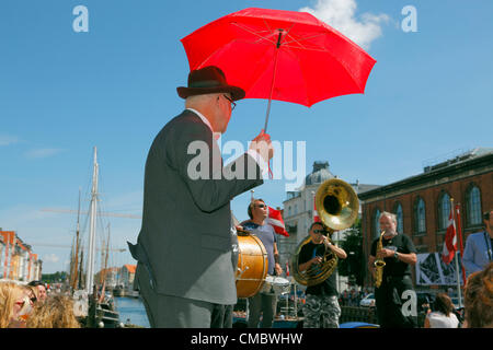 Juli Freitag 13, 2012 - drängten sich die beliebte Straßenumzug und traditionellen jazz-Band - The Orion Brass Band spielt mit Performer und Atmosphäre Schöpfer in Nyhavn, Kopenhagen, Dänemark, an einem warmen und sonnigen Freitag Nachmittag voller Touristen während der Copenhagen Jazz Festival. Stockfoto