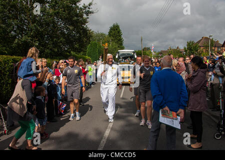 Copthorne, West Sussex, UK. 17. Juli 2012. Getragen wird die Olympische Fackel durch Copthorne von Derek Day. Derek spielte in der Großbritannien-Eishockey-Team, das Bronzemedaille bei den Olympischen Spielen 1952 gewann. Damals gab es nur 11 Medaillen vergeben und so verpasst er und eines der anderen Gruppenmitglieder erhalten eine Medaille. In Partnerschaft mit der BOA, GB Hockey in der Lage, hier Abhilfe zu schaffen wurde im Jahr 2010 erhielt er eine Medaille von der ursprünglichen Besetzung gemacht. Stockfoto