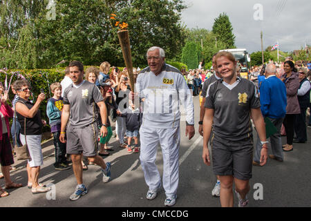 Copthorne, West Sussex, UK. 17. Juli 2012. Getragen wird die Olympische Fackel durch Copthorne von Derek Day. Derek spielte in der Großbritannien-Eishockey-Team, das Bronzemedaille bei den Olympischen Spielen 1952 gewann. Damals gab es nur 11 Medaillen vergeben und so verpasst er und eines der anderen Gruppenmitglieder erhalten eine Medaille. In Partnerschaft mit der BOA, GB Hockey in der Lage, hier Abhilfe zu schaffen wurde im Jahr 2010 erhielt er eine Medaille von der ursprünglichen Besetzung gemacht. Stockfoto