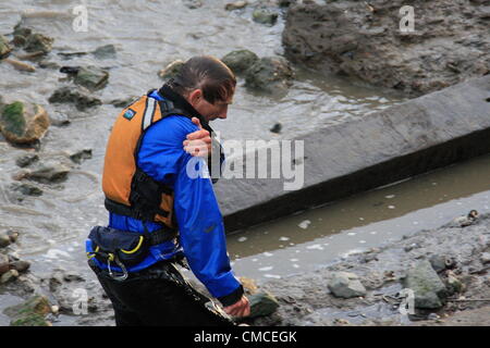 Greenwich, London, UK. Dienstag, 17. Juli 2012. Ein verletzter Kanute macht seinen Weg am Ufer nach Kanus durch die Wäsche von London River Taxi auf der Themse umgeworfen wurden. Ein Polizeiboot Gefahren, um die Szene nach rund ein halbes Dutzend Kanuten wurden von der Wäsche getroffen. Eines der Kanuten musste von Rettungsboot mitgenommen werden. Stockfoto