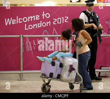 18.07.2012. London, England.  Ein bewaffneter Polizist beobachtet einen Passagier Sicherheitsmaßnahmen verstärkte am Flughafen Heathrow in London, Großbritannien, 18. Juli 2012 gewesen. Die Olympischen Spiele 2012 in London wird am 27. Juli 2012 beginnen. Stockfoto