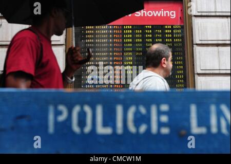 20. Juli 2012 - Manhattan, New York, USA - Menschen betrachten über Spielzeiten der AMC 25 Theater am Times Square nach Batman "Dark Knight Rises" Theater Dreharbeiten in Aurora, Colorado. Mindestens 12 Menschen wurden getötet und mehr als 50 verletzt während der Mitternacht-Premiere des Films an den Jahrhundert 16 Kinos in Aurora. (Bild Kredit: Bryan Smith/ZUMAPRESS.com ©) Stockfoto