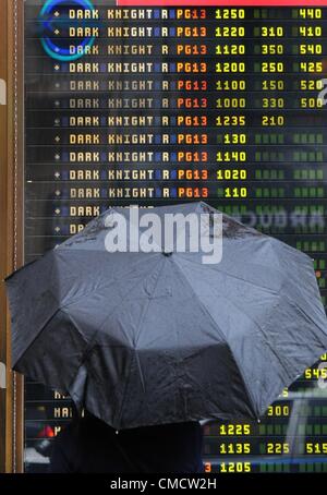 20. Juli 2012 - Manhattan, New York, USA - Menschen betrachten über Spielzeiten der AMC 25 Theater am Times Square nach Batman "Dark Knight Rises" Theater Dreharbeiten in Aurora, Colorado. Mindestens 12 Menschen wurden getötet und mehr als 50 verletzt während der Mitternacht-Premiere des Films an den Jahrhundert 16 Kinos in Aurora. (Bild Kredit: Bryan Smith/ZUMAPRESS.com ©) Stockfoto