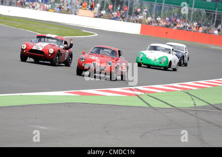 22. Juli 2012, Silverstone im Vereinigten Königreich.  Der Fahrer des Martin Hunt und Patrick Blakeney-Edwards' AC Cobra-Getures aus dem Fenster während der Royal Automobile Club Tourist Trophy für historische Fahrzeuge (Pre-63GT) Rennen in Silverstone Classic 2012 Stockfoto