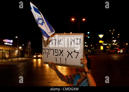 Eine Frau hält ein hebräisches Pappschild mit der Aufschrift „Dies ist Israel und nicht Afrika“ während einer Demonstration gegen afrikanische Wanderarbeiter und Asylsuchende, die in südlichen Vororten von Tel Aviv leben und die sofortige Ausweisung aller illegalen afrikanischen Einwanderer aus Israel fordern. Stockfoto