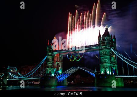 London, England, UK Freitag, 27. Juli 2012 Tower Bridge Feuerwerk Licht auf der Themse, als die Olympische Fackel die letzte Etappe der Reise zum Olympischen Stadion fährt. London, Gastgeber der 30. Olympischen Spiele vorbereitet für die Eröffnungsfeier mit einem Feuerwerk und Licht zeigen auf Tower Bridge, City of London, England, UK Stockfoto