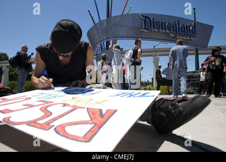 28. Juli 2012 - Anaheim, Kalifornien, USA - A-Demonstrator stellt den letzten Schliff auf einem Schild am Eingang Süd Hafen nach DIsneyland am Samstagnachmittag... ---Mehrere Dutzend Demonstranten erschienen am Eingang zum Disneyland auf South Harbor Blvd. Samstag mit Schilder und Plakate protestieren die jüngsten Dreharbeiten Todesfälle von mehreren jungen Männern in Auseinandersetzungen mit der Polizei von Anaheim, Manuel Diaz, 25 einschließlich beteiligt, die Bewohner sagen war unbewaffnet. (Kredit-Bild: © David Bro/ZUMAPRESS.com) Stockfoto