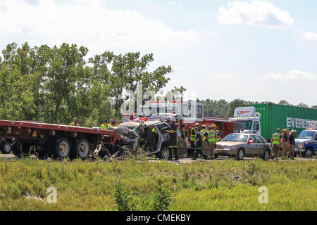 Montag, 30. Juli 2012--Emergency Arbeitnehmer klar die Szene eines tödlichen Unfalls in der Nähe von Hudson, Wisconsin, USA. Der Unfall ereignete sich, als ein Sport Utility Vehicle in der Rückseite des Semi-Tieflader auf i-94 nahe Meilenmarkierung 6 stürzte, verursacht mindestens einen Todesfall. Stockfoto