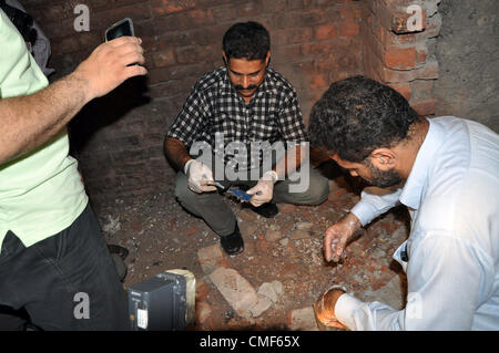 2. August 2012. Pakistanische Polizeibeamte untersuchen Ortsbild des Twin Explosionen auf einem Obstmarkt in Lahore 2. August 2012. Mindestens 23 Menschen wurden verletzt, als zwei Explosionen die Stadt während der Nachtstunden erschüttert. Stockfoto