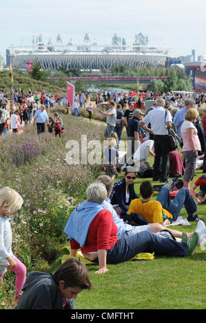 Zuschauer entspannen Sie im Park Live 2012 London Olympic Park, mit Blick auf das 2012-Athletcis-Stadion in der Ferne auf Freitag, 3. August 2012. Stockfoto