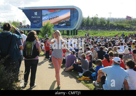 Zuschauer genießen die Sonne und die live TV-Berichterstattung von den Olympischen Spielen im Park Live im 2012 Olympic Park, London auf Freitag, 3. August 2012. Stockfoto