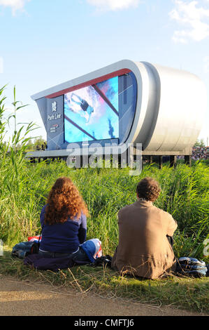 Zwei Zuschauer sehen die live TV-Berichterstattung von den Olympischen Spielen im Park Live im 2012 Olympic Park, London auf Friaday 3. August 2012. Stockfoto