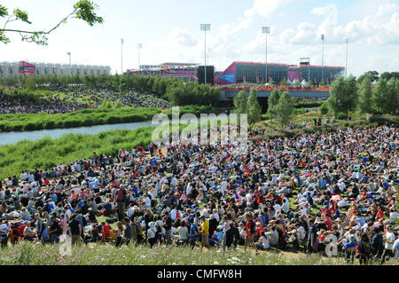 Kundenansturm bei Sonnenschein, Watch live TV-Berichterstattung der Olympischen Finals auf dem großen TV-Bildschirm im Park Live im 2012 Olympic Park, London am 3. August 2012. Stockfoto