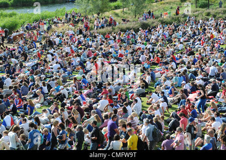 Kundenansturm bei Sonnenschein, Watch live TV-Berichterstattung der Olympischen Finals auf dem großen TV-Bildschirm im Park Live im 2012 Olympic Park, London am 3. August 2012. Stockfoto